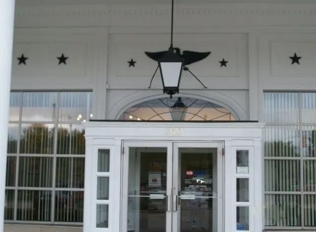 Front entrance with double glass doors, white trim, star decorations, and a hanging lantern.