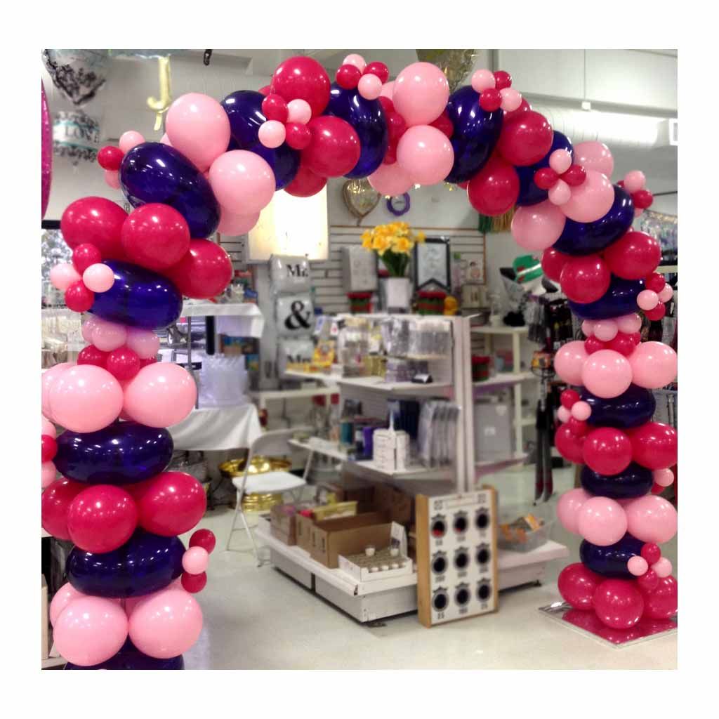 A store is decorated with pink and blue balloons