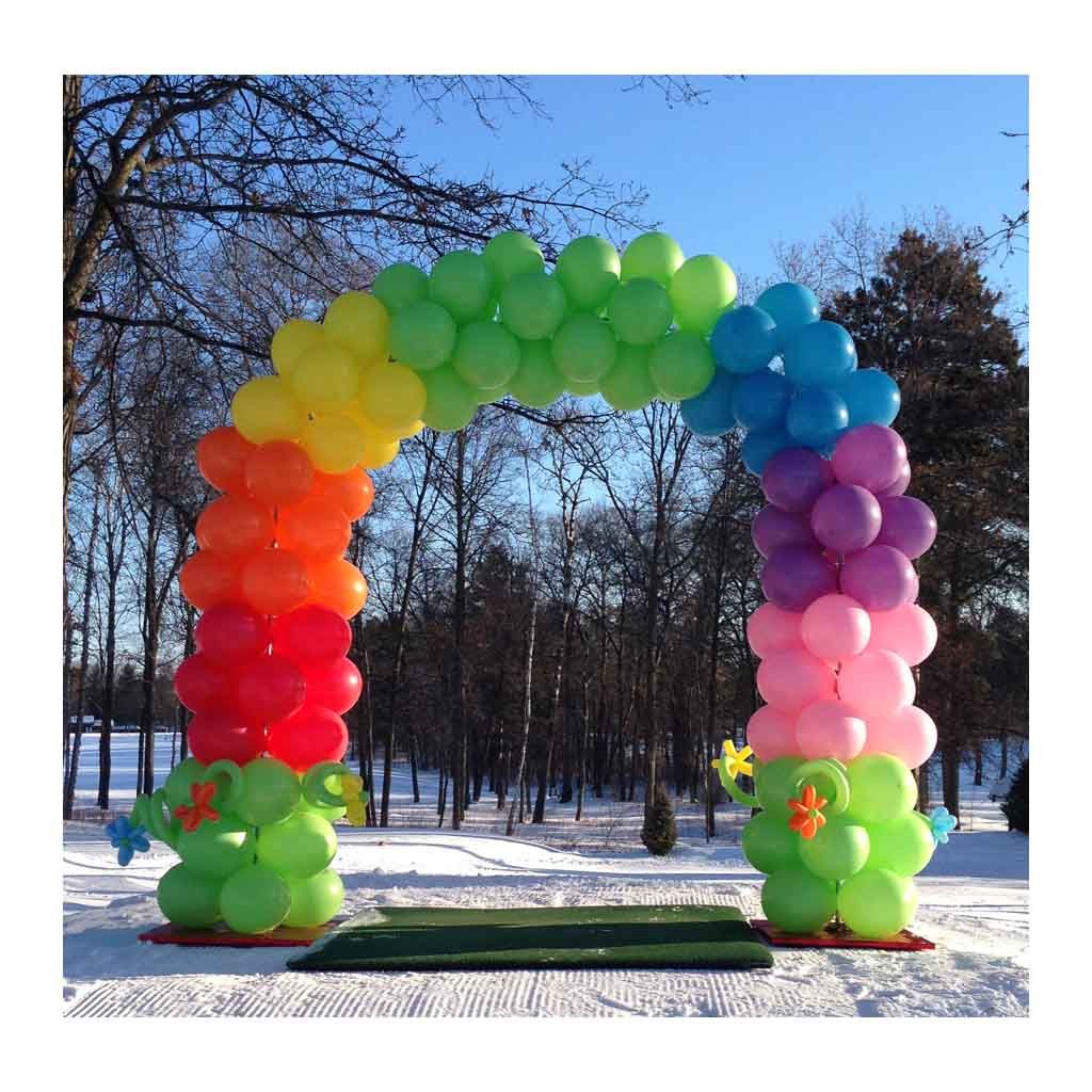 A rainbow colored arch made of balloons in the snow