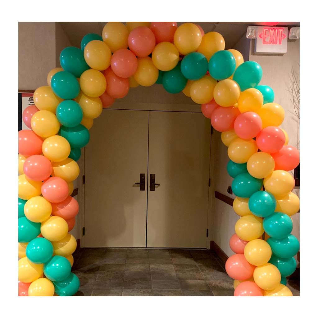 A doorway is decorated with balloons and a red exit sign