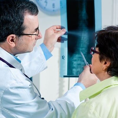Lower Back — Doctor Pointing At The X-Ray of a Spine With Patient in Greenwood, SC