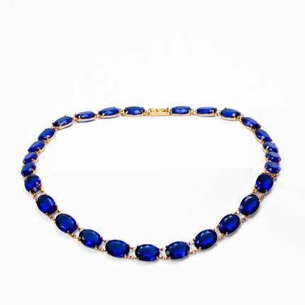 Gold plated statement earrings featuring amethyst (purple gemstones) surrounded by zirconia (clear gemstones), imperial topaz (golden-pink gemstones), tourmaline, blue and yellow topaz (golden gemstones), and garnet (red gemstones)