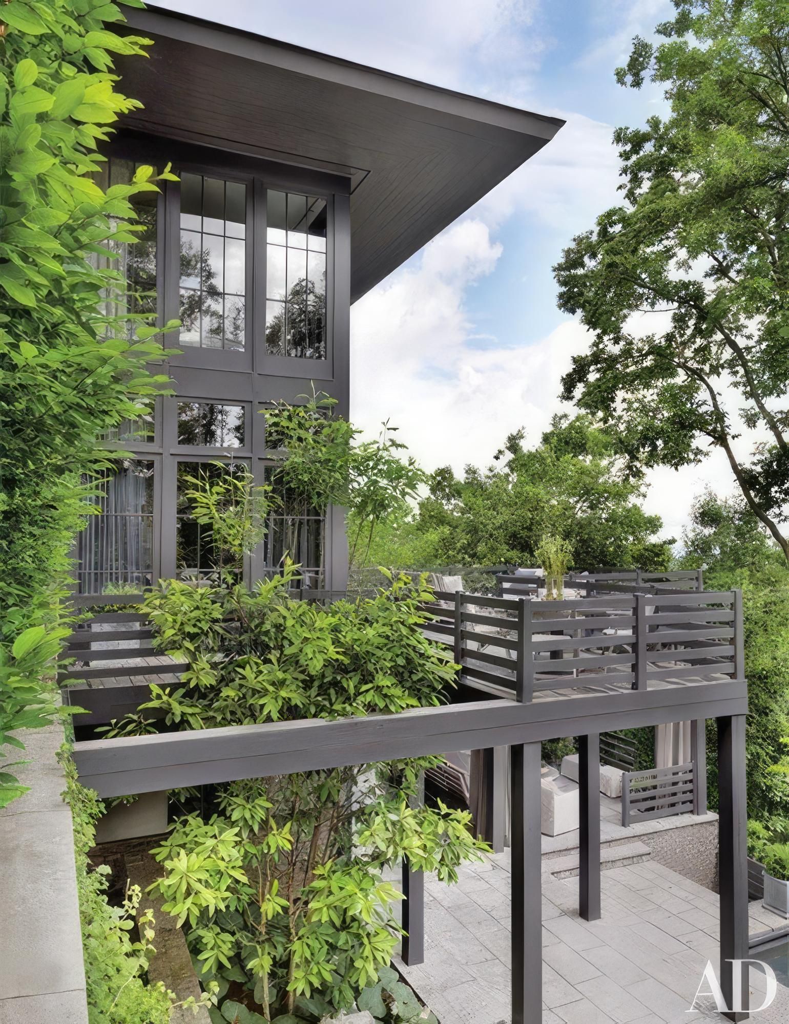 A house with a balcony and trees in front of it