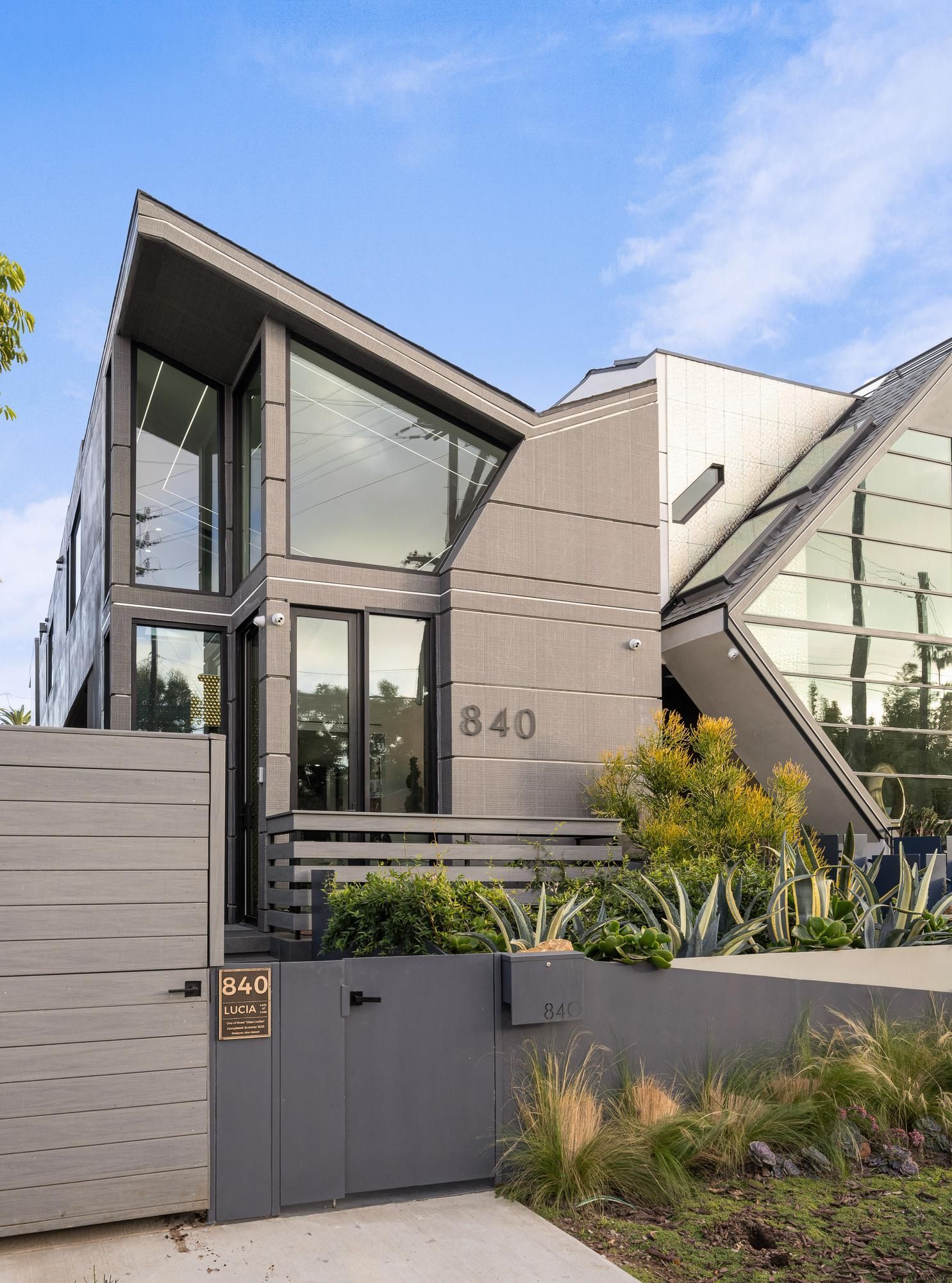 A modern house with a lot of windows and a gate