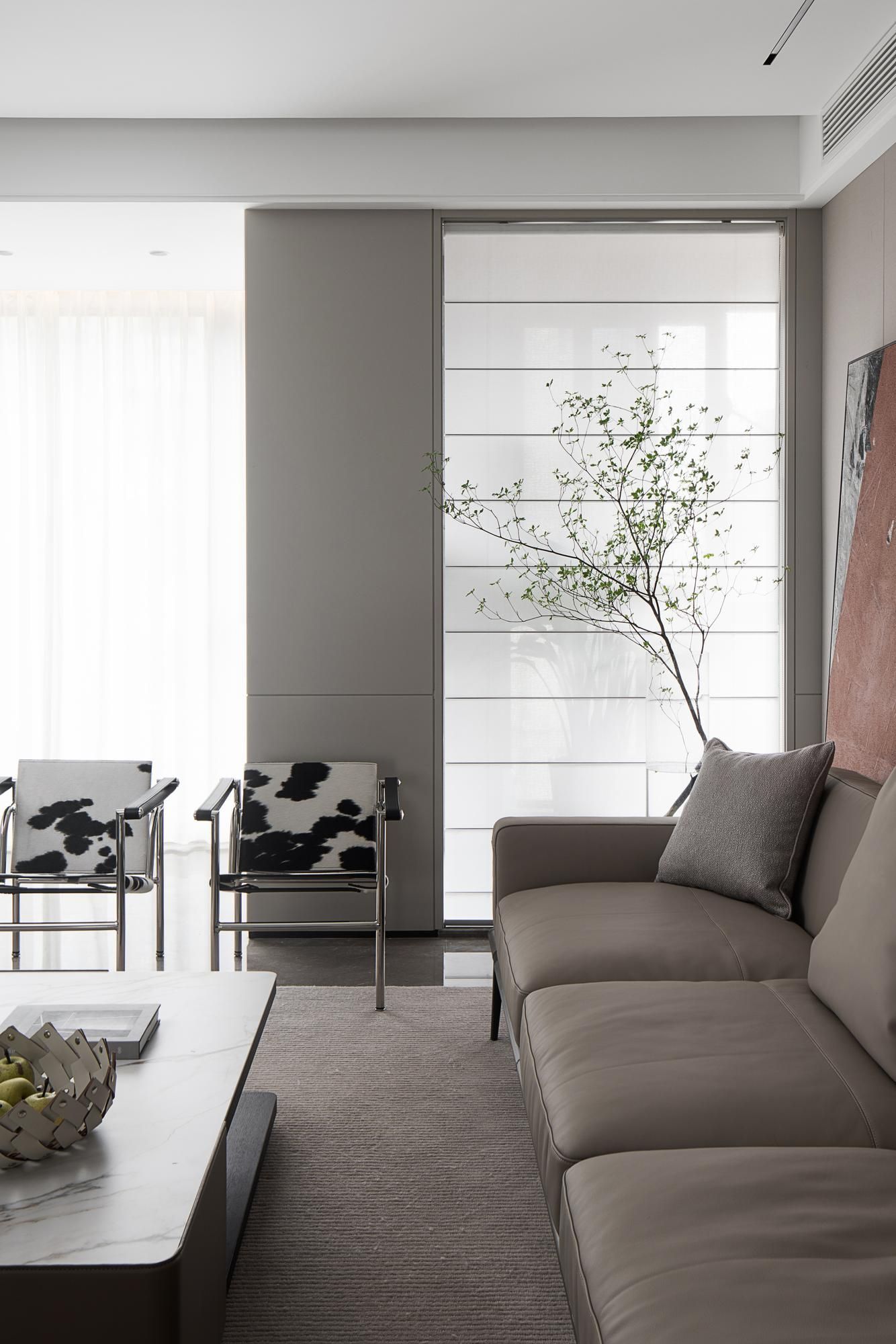 A living room with a couch , chairs , and a coffee table.