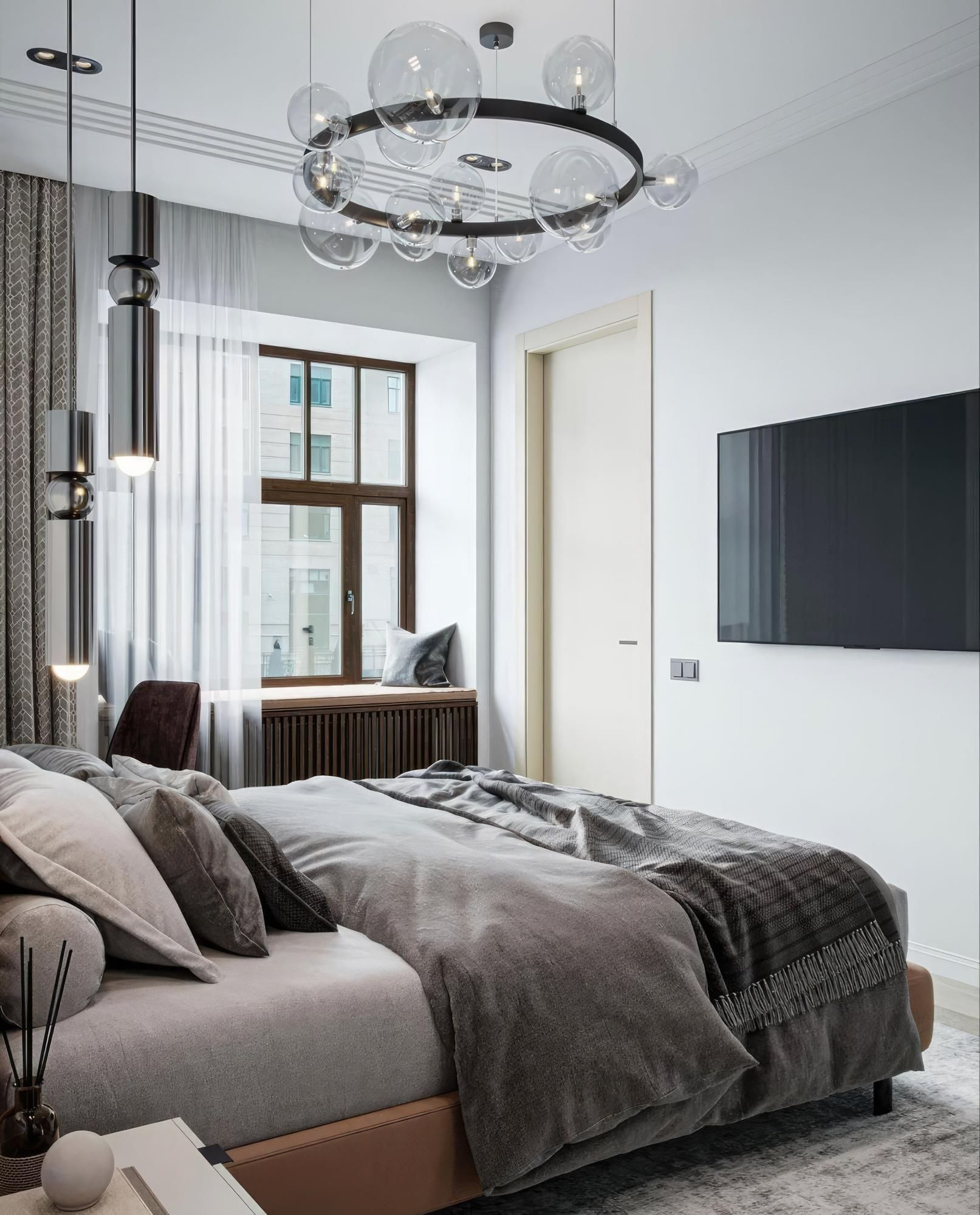 A bedroom with a large bed and a flat screen tv on the wall.