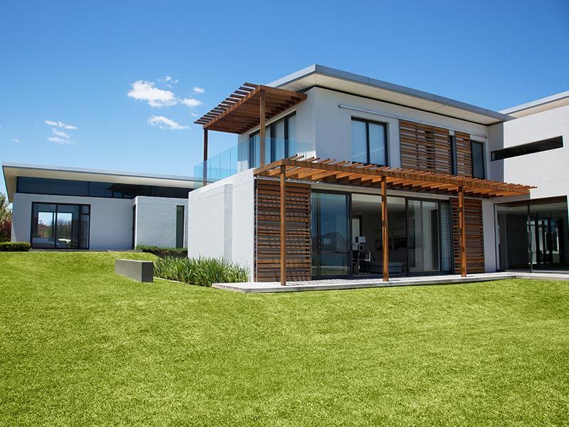 A modern house with a large lawn in front of it.