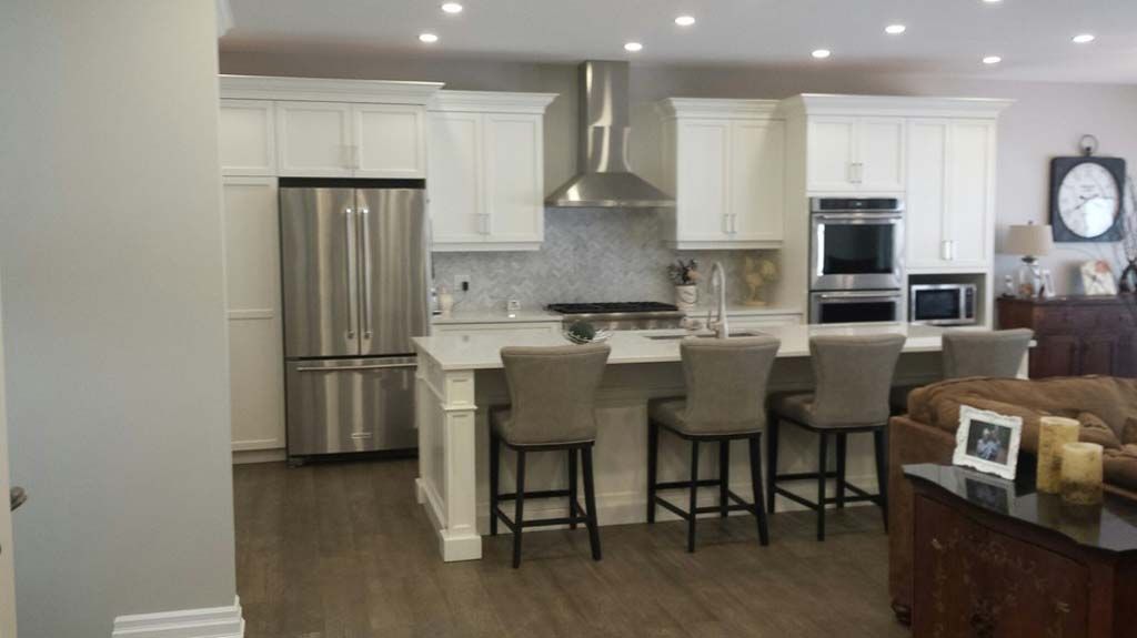 A kitchen with white cabinets and stainless steel appliances