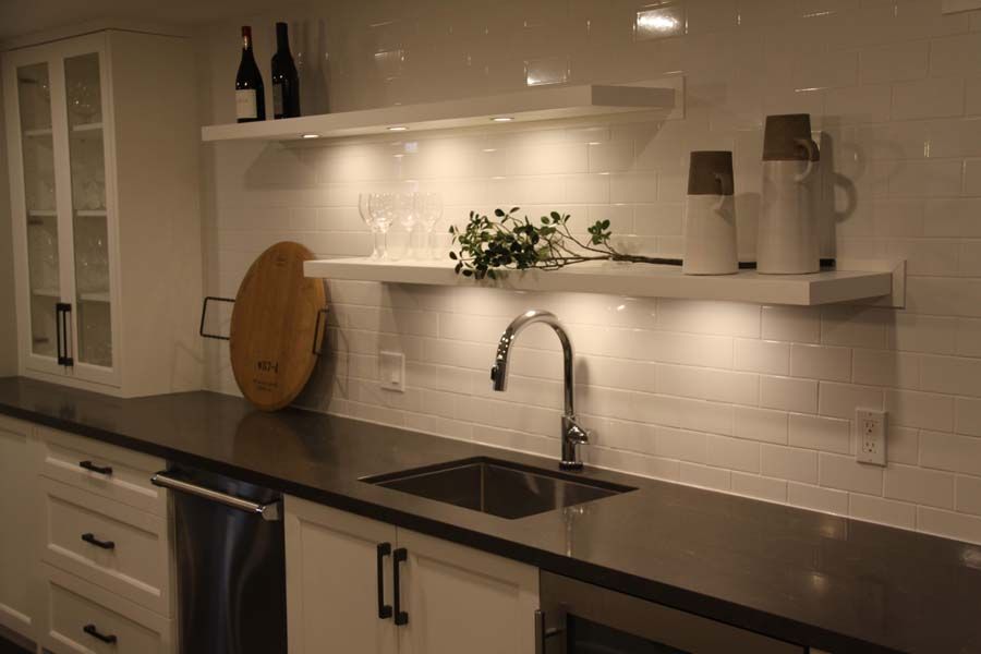 A kitchen with a sink and a cutting board on the counter.