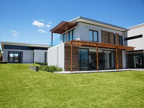 A modern house with a large lawn in front of it.