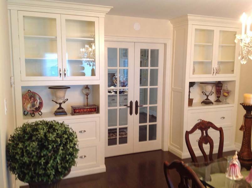 A dining room with white cabinets and french doors