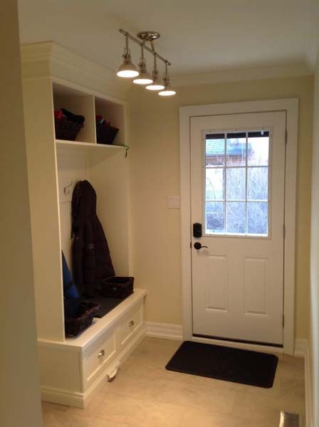 A hallway with a white door and a bench