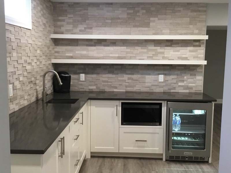 A kitchen with a sink , refrigerator , and shelves.