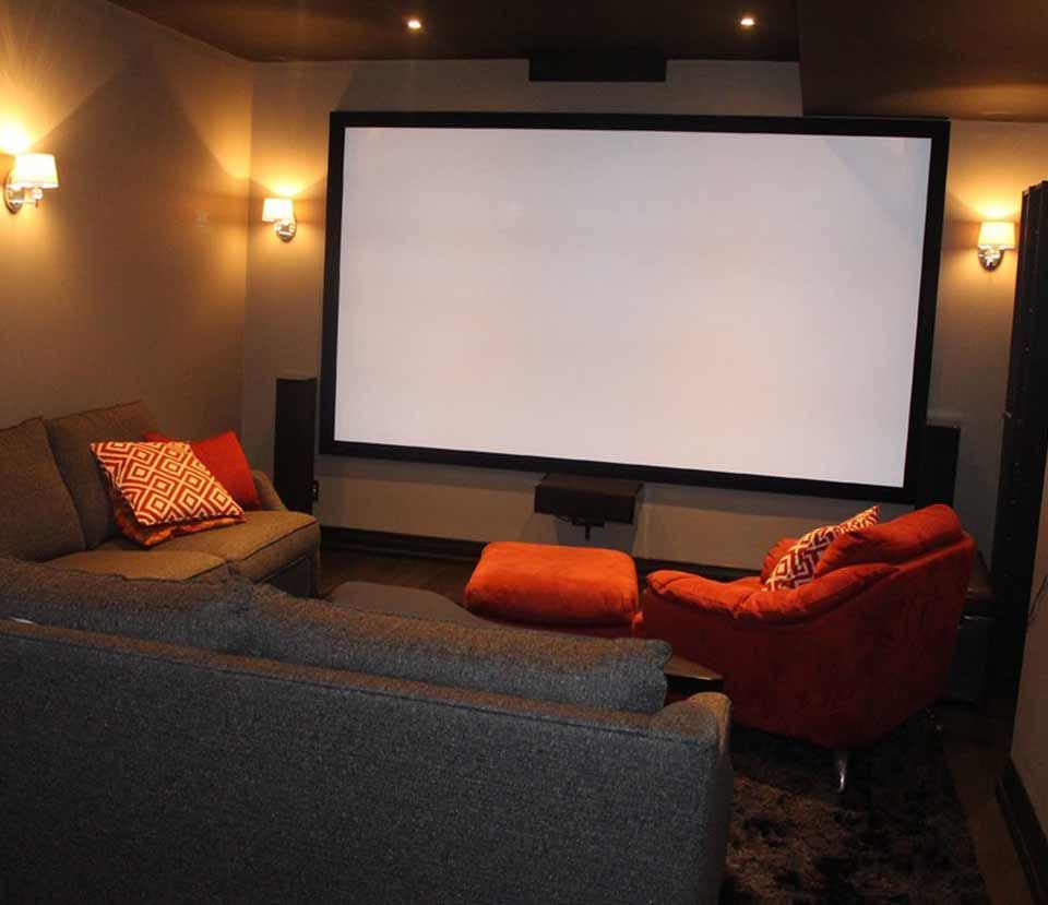 A living room with a large screen and a couch