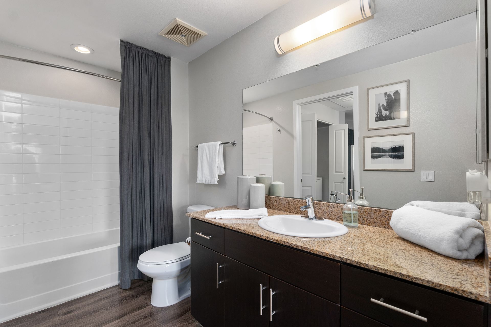 A bathroom with a sink , toilet , bathtub and mirror.