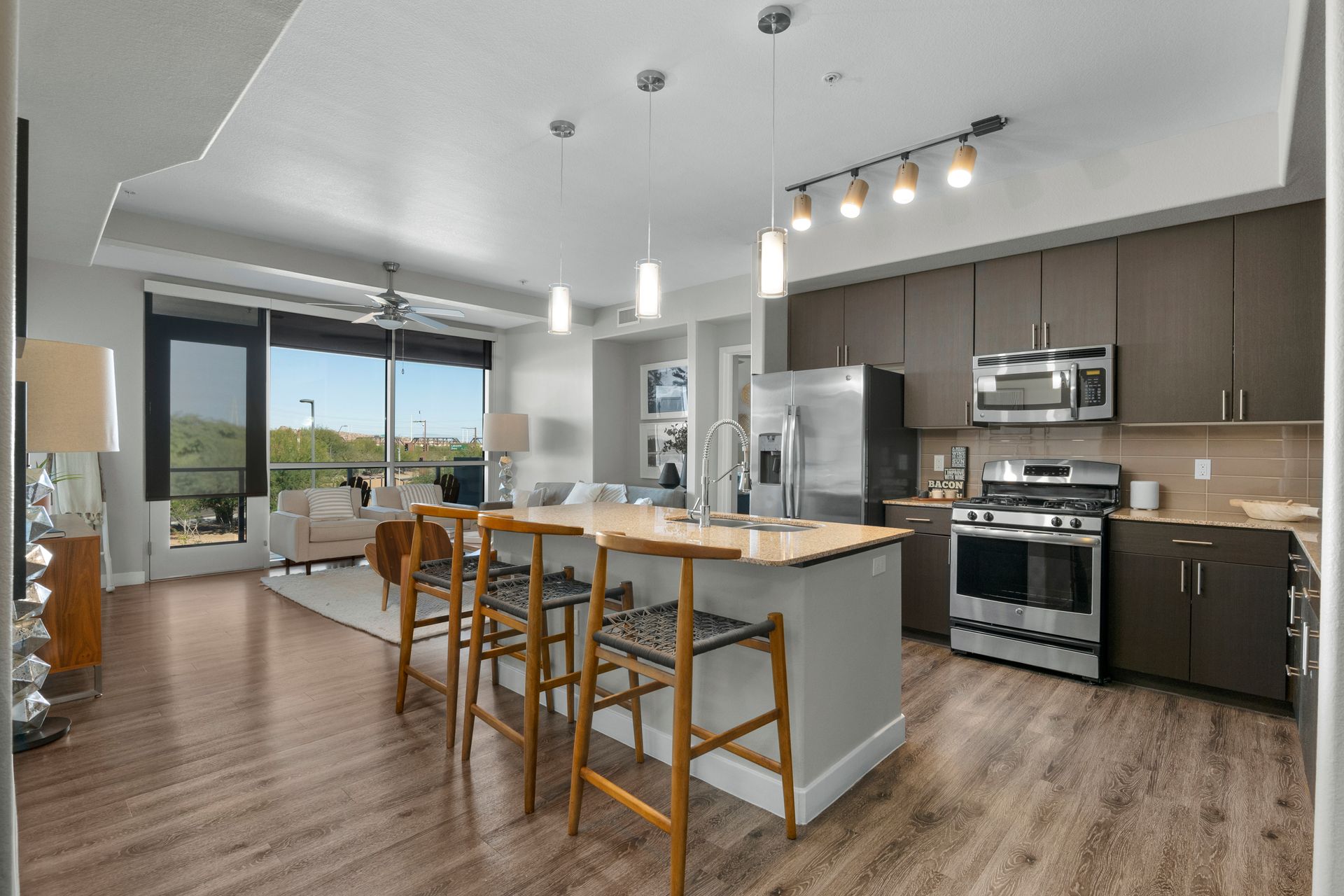 A kitchen with stainless steel appliances , wooden floors and a large island.