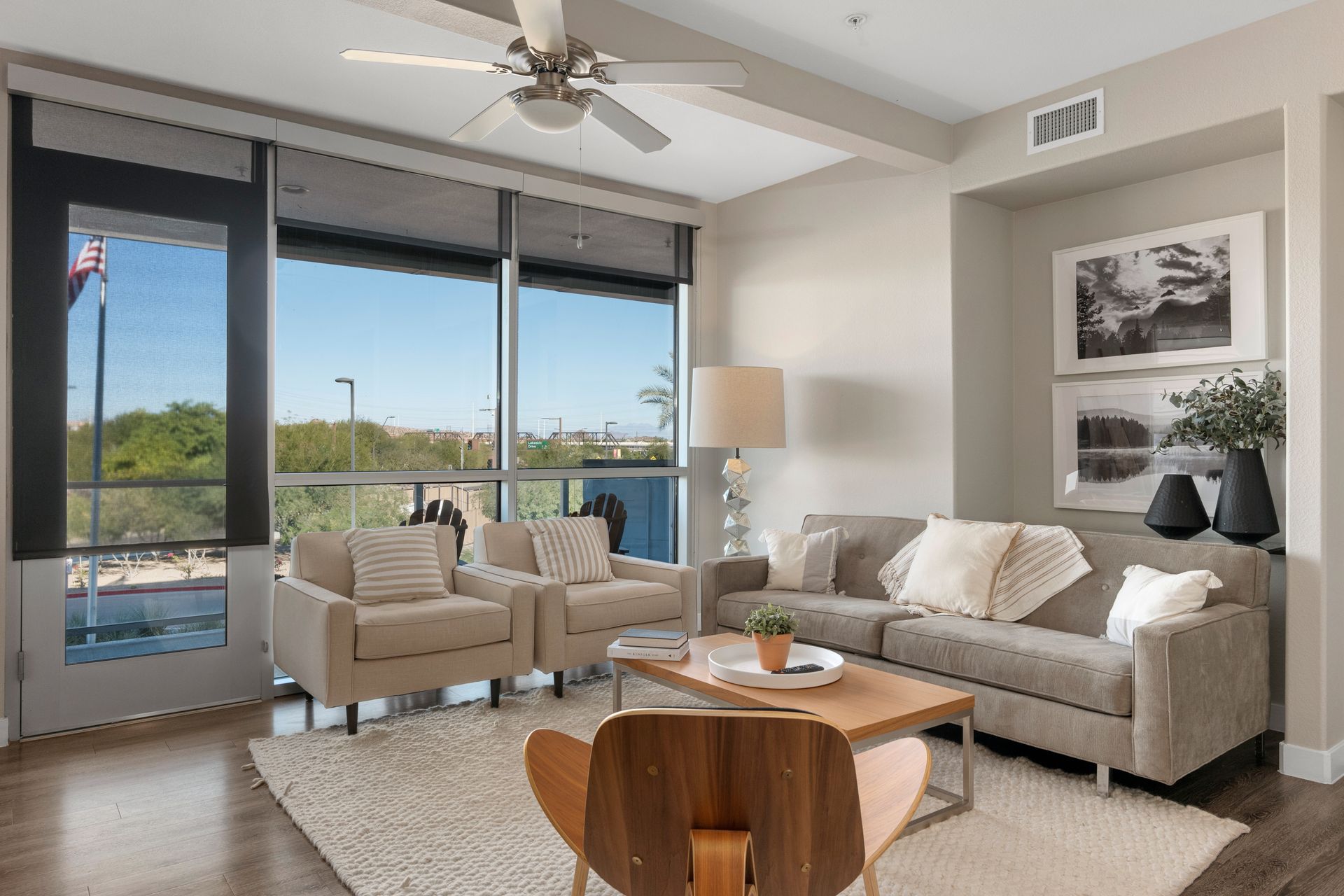 A living room with a couch , chairs , coffee table and ceiling fan.