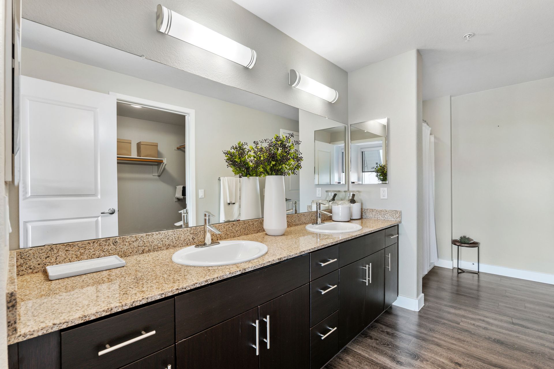 A bathroom with two sinks and a large mirror.