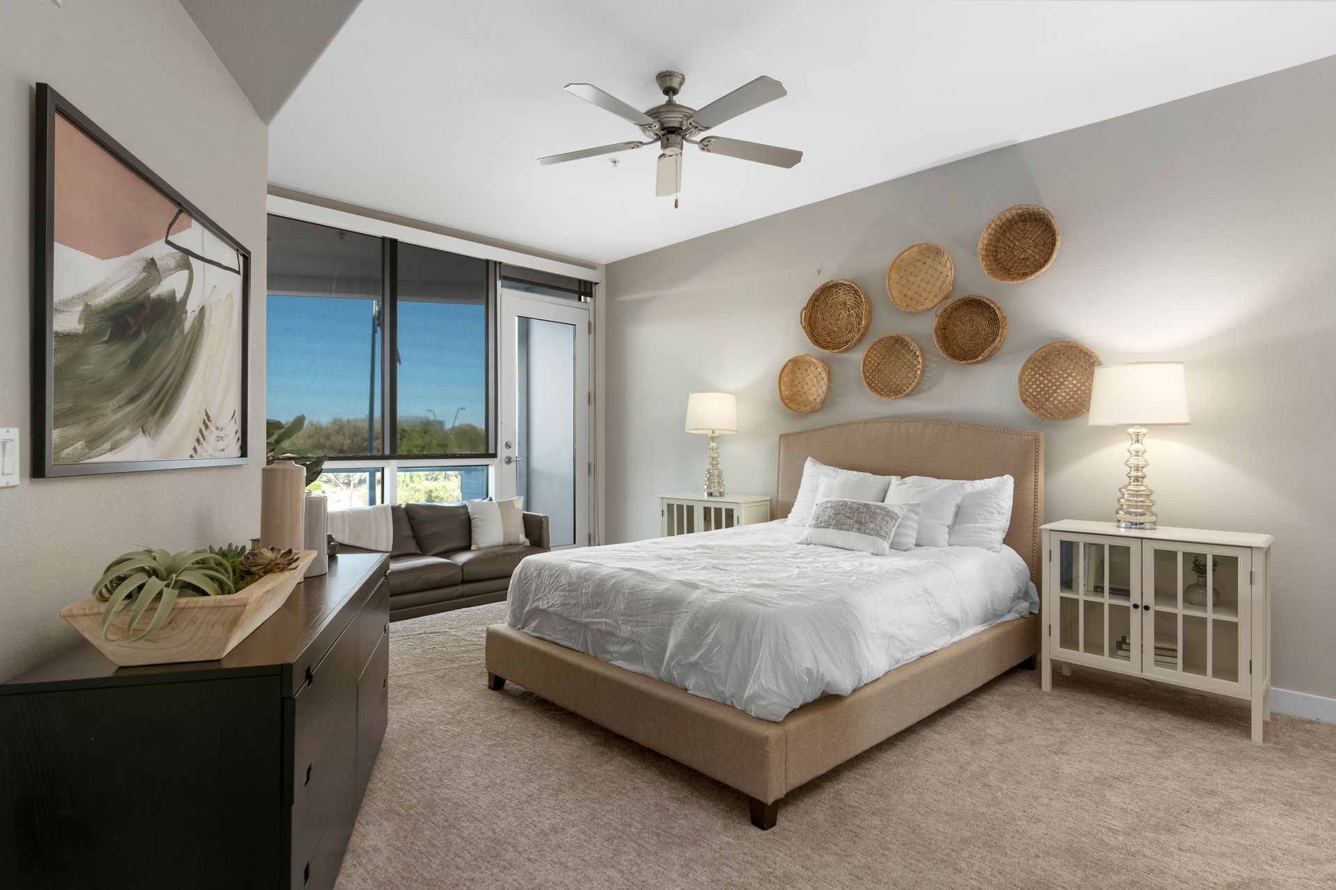 A bedroom with a large bed and a ceiling fan.