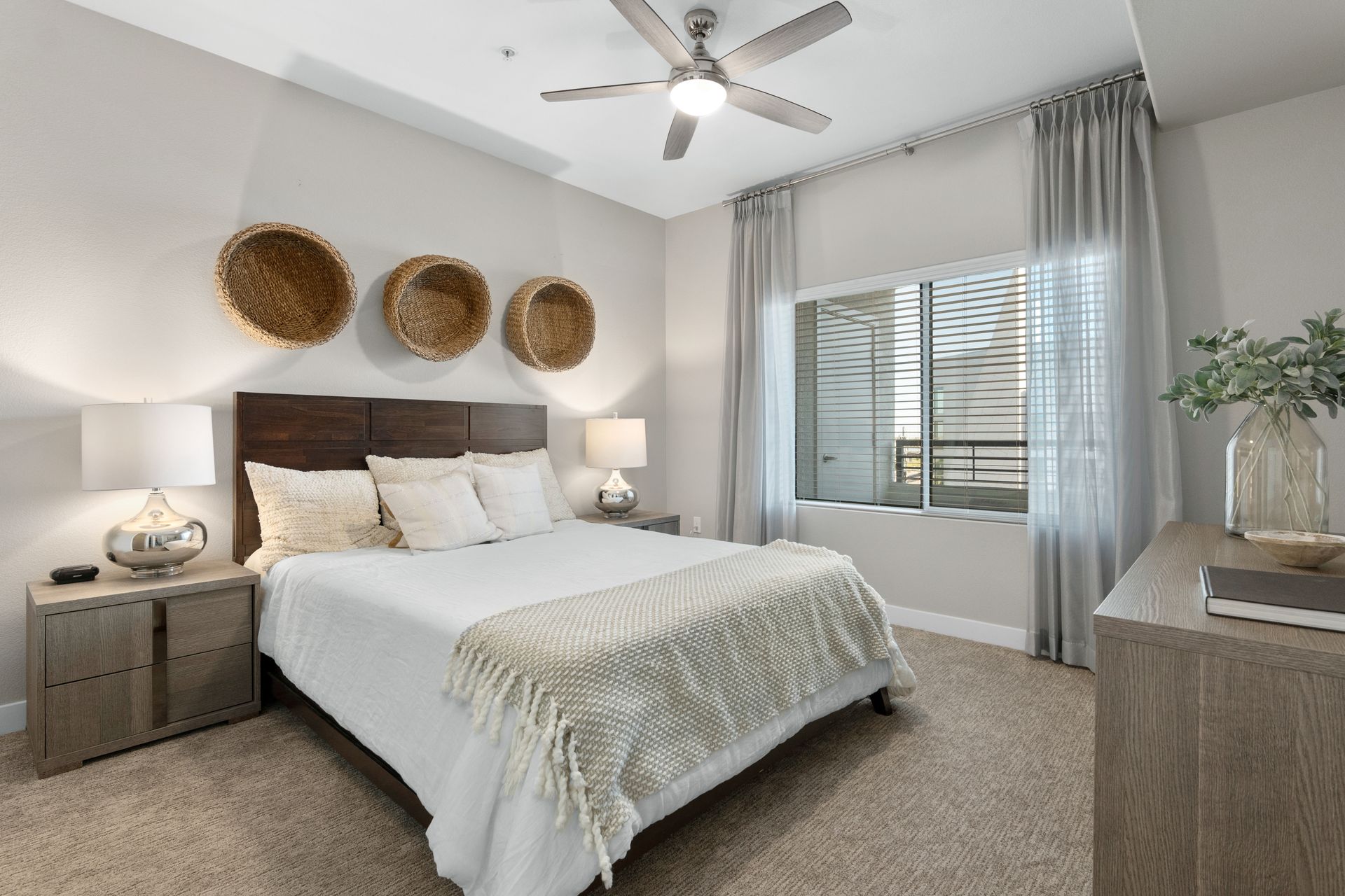 A bedroom with a large bed and a ceiling fan.