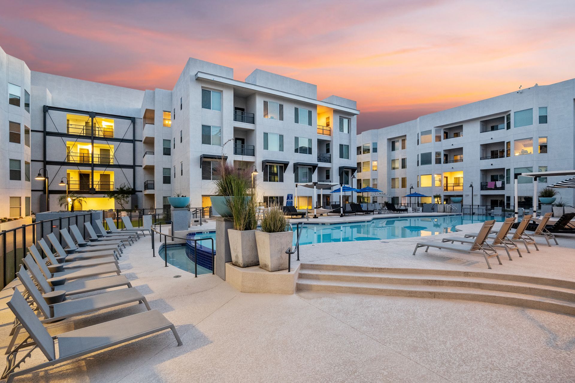 A large apartment building with a swimming pool in front of it.