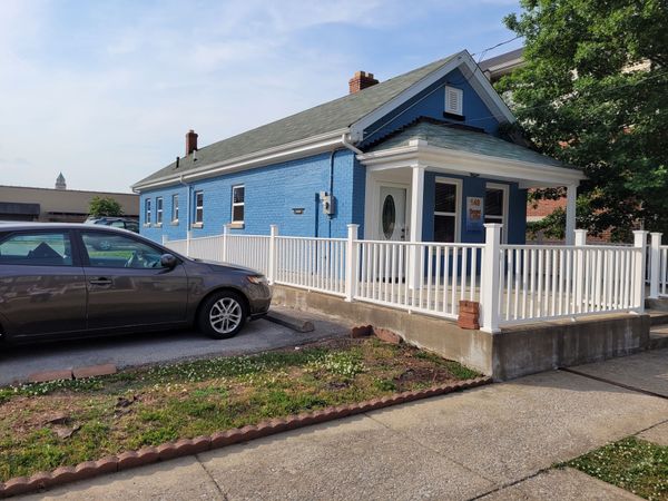 A blue house with a car parked in front of it