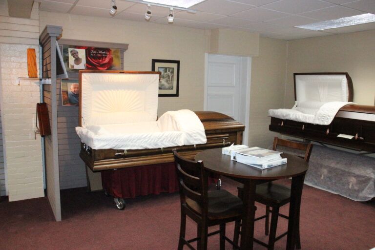 A room with two coffins and a table and chairs