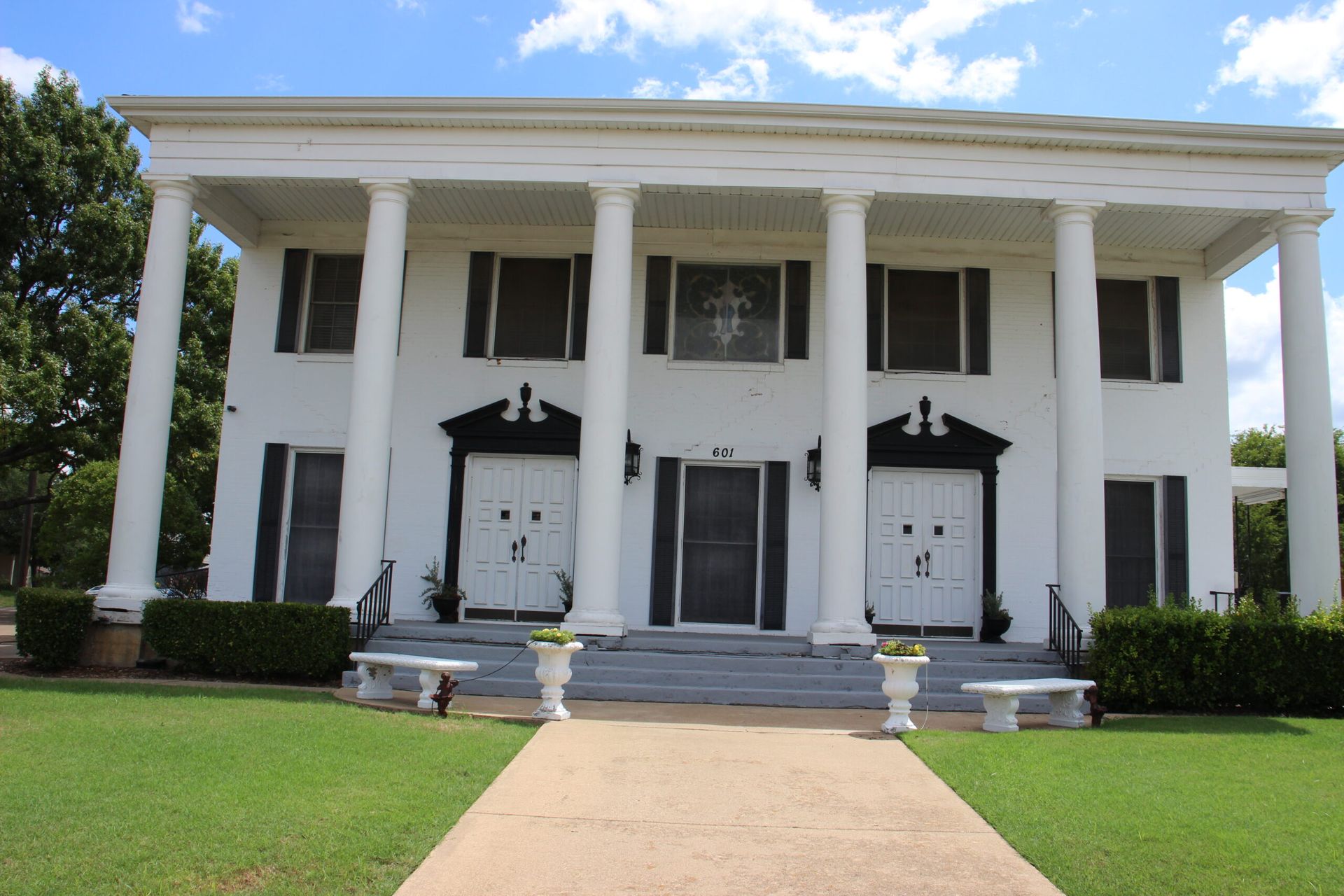 A large white house with columns and black doors