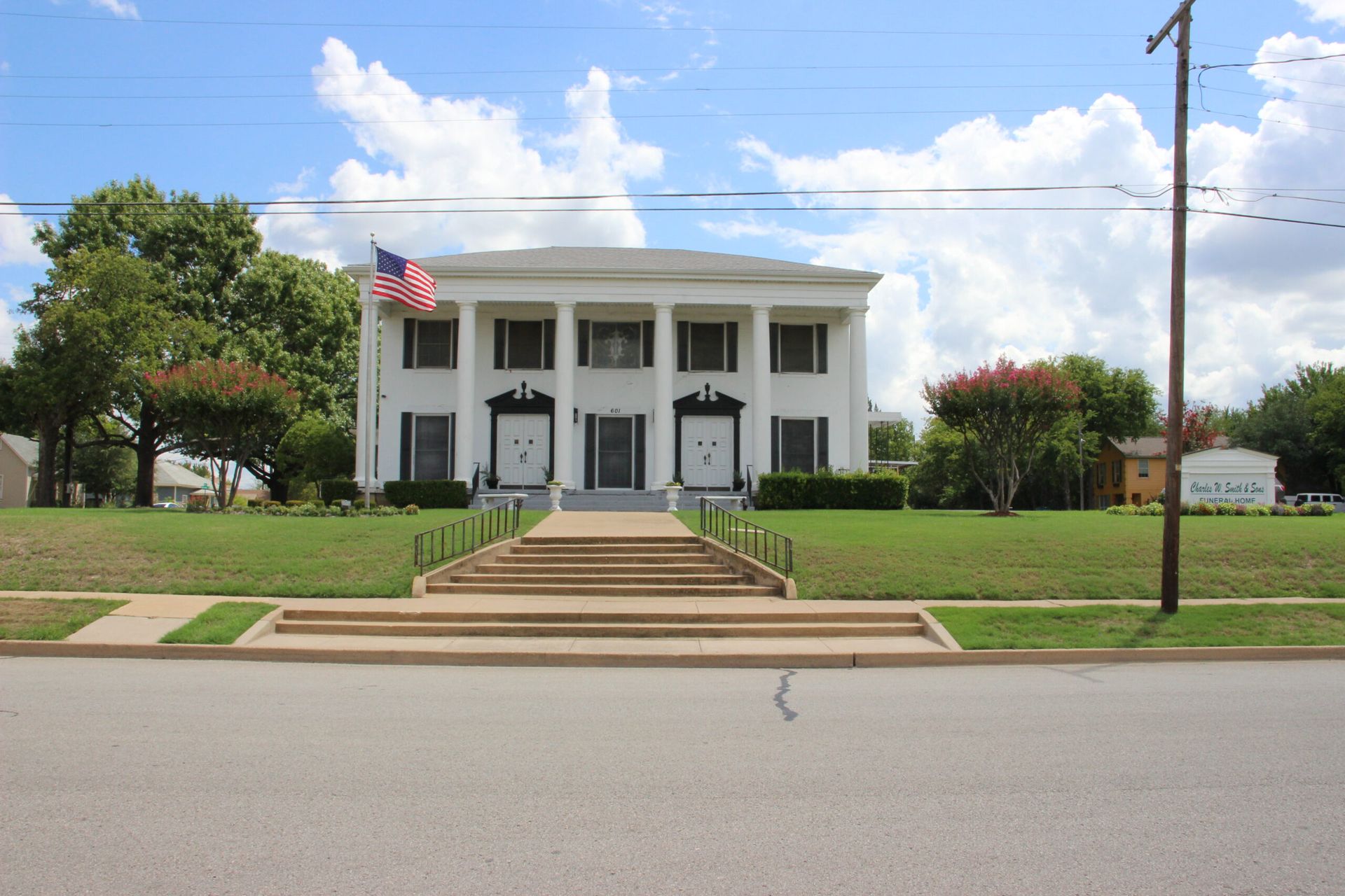 A large white house with an american flag on top of it