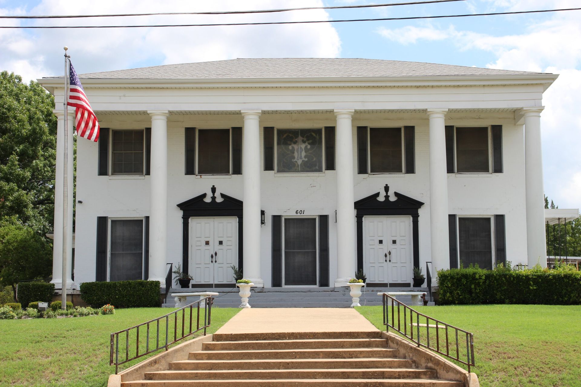 A large white building with a flag in front of it