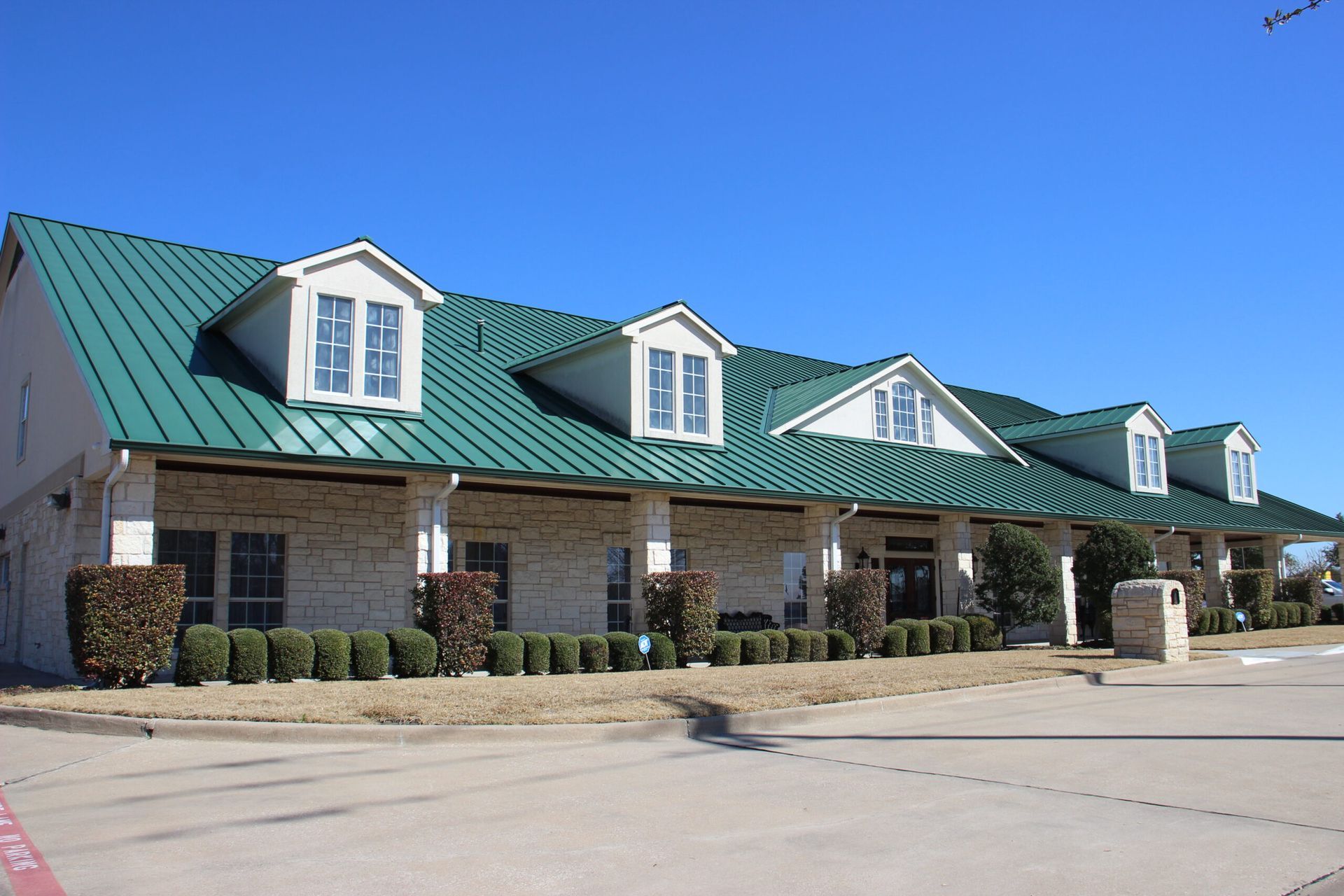 A building with a green roof and white trim