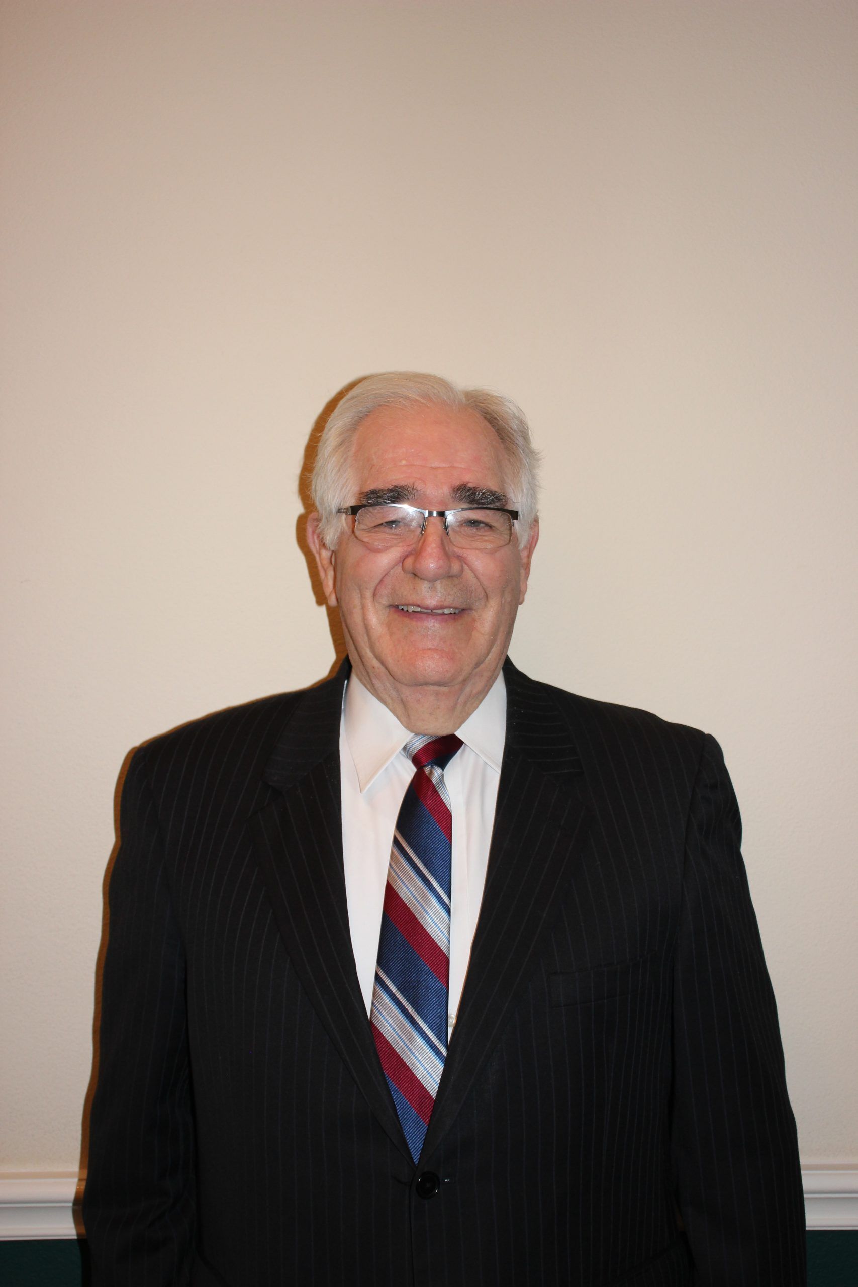 A man in a suit and tie is smiling for the camera