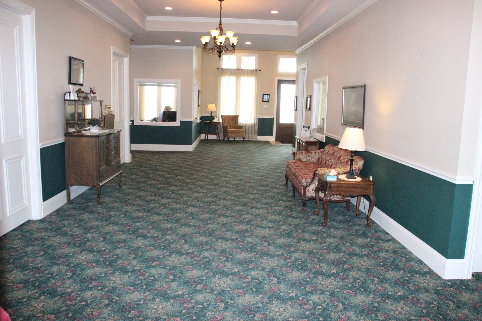 A long hallway with green carpet and green walls