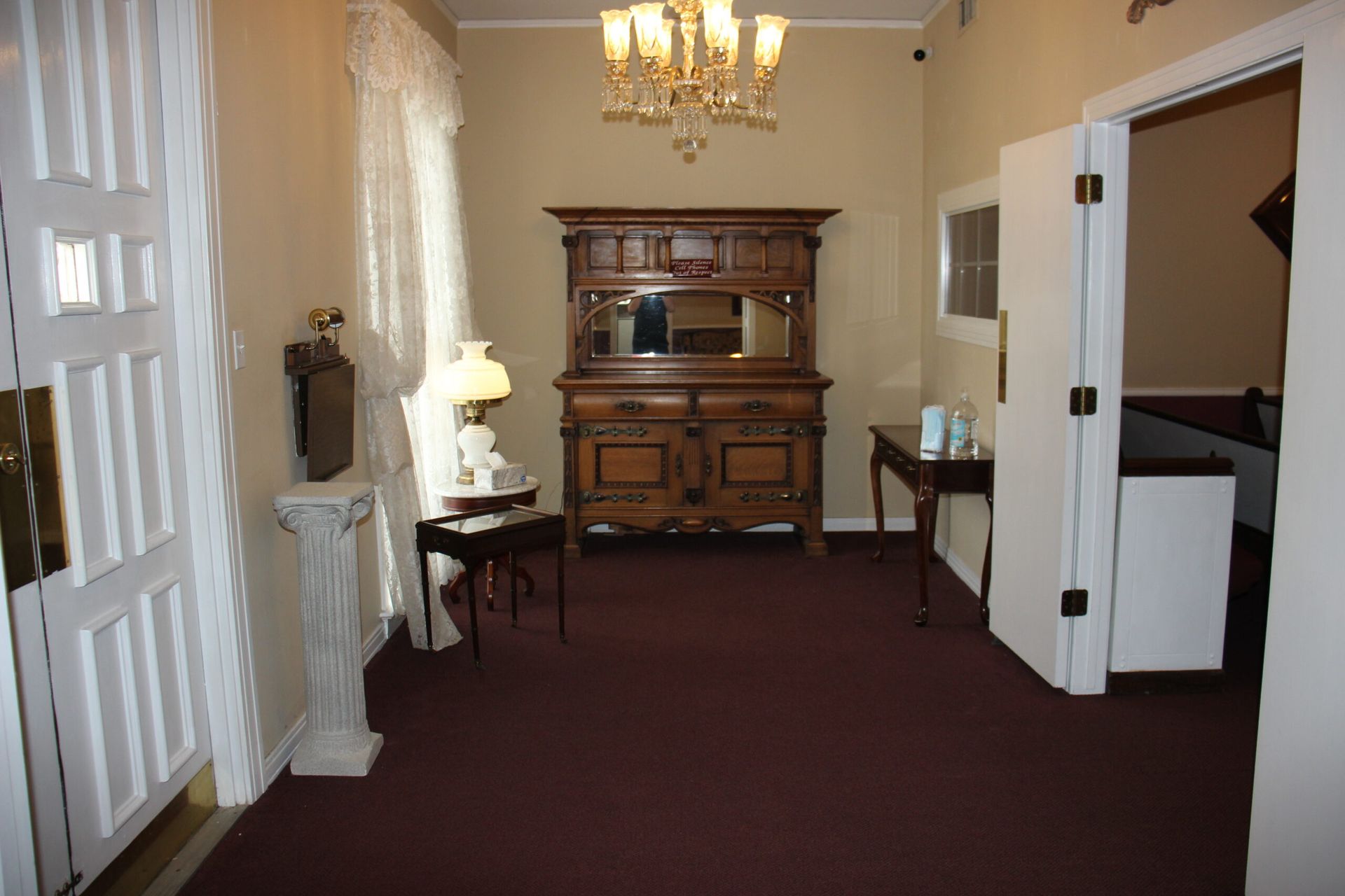 A room with a dresser and a chandelier in it