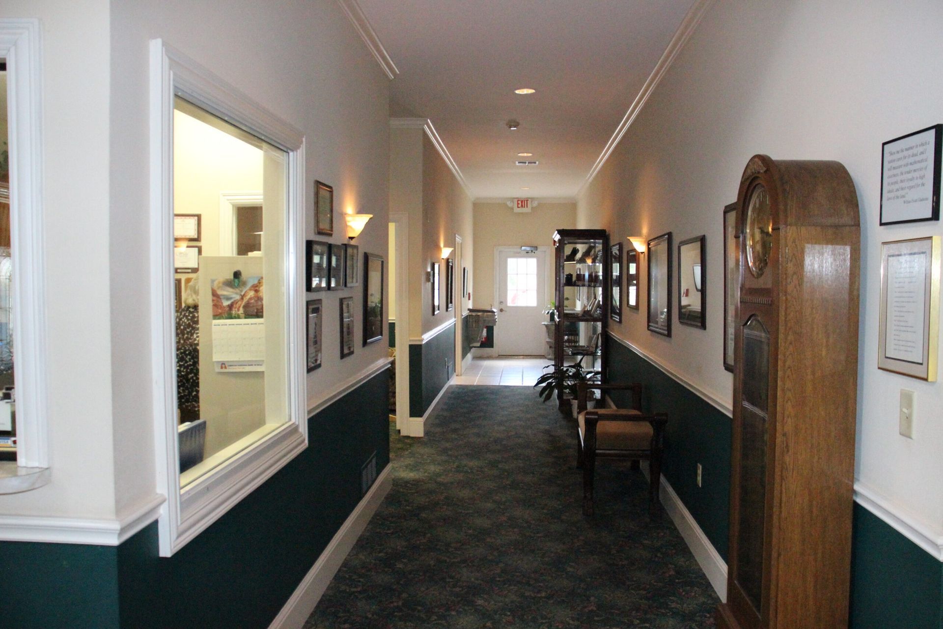 A long hallway with a clock on the end of it