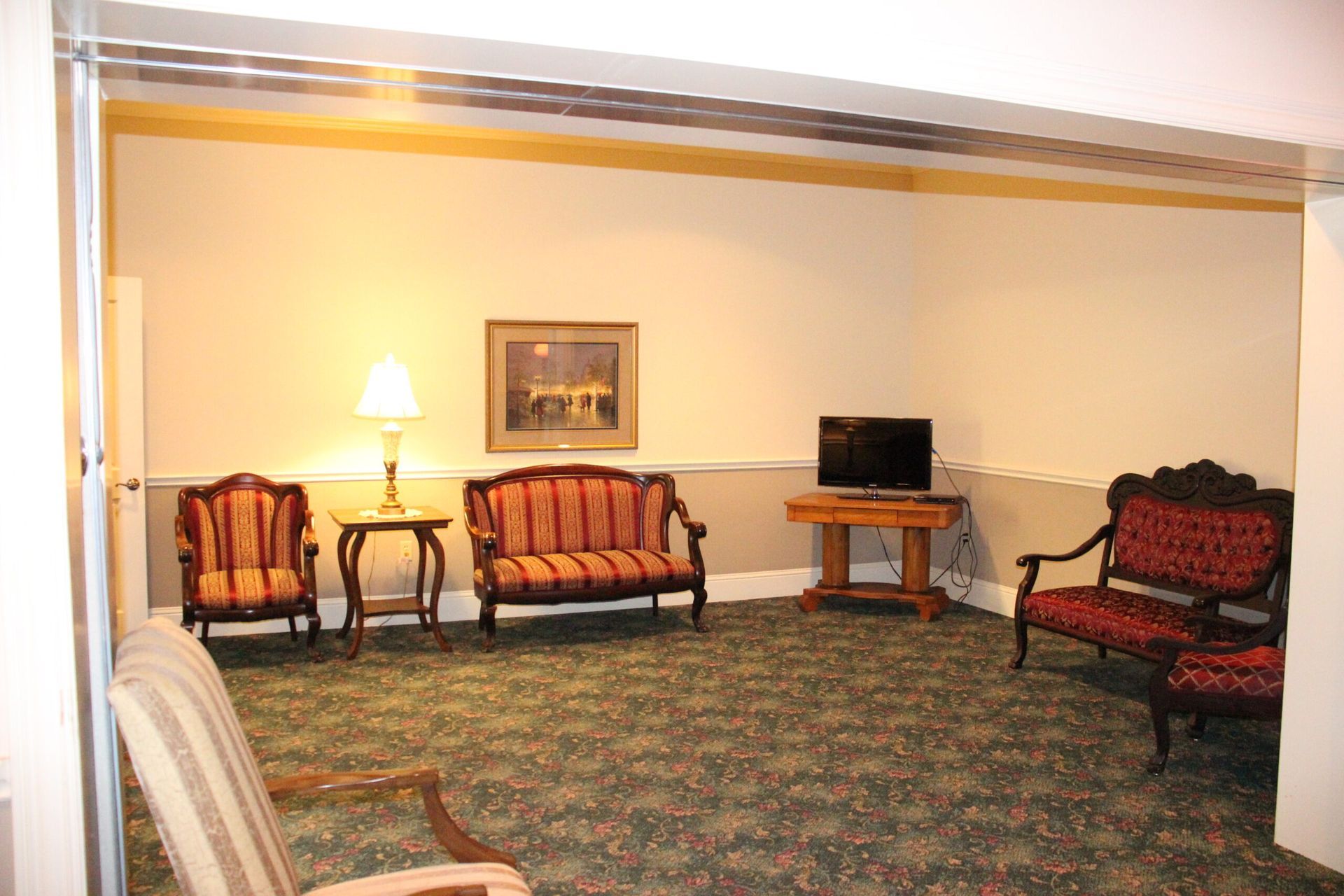 A living room with a couch and chairs and a television