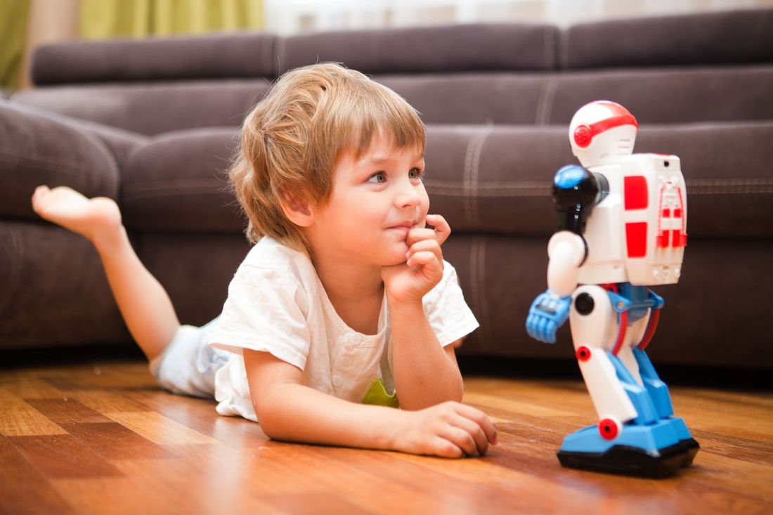 bambino felice con robot telecomandato