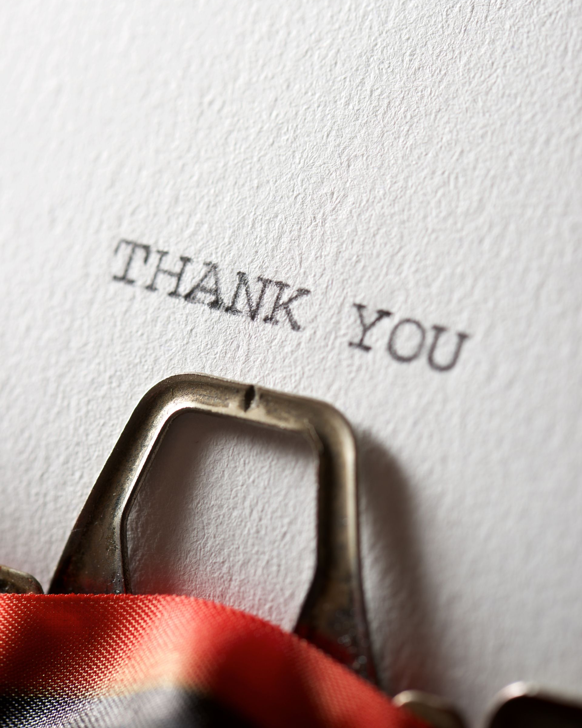 A close-up of a typewriter ribbon and guide typing the words 
