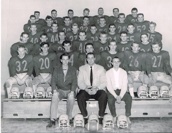 Vintage football team portrait with coaches seated in front and players in uniforms arranged on bleachers