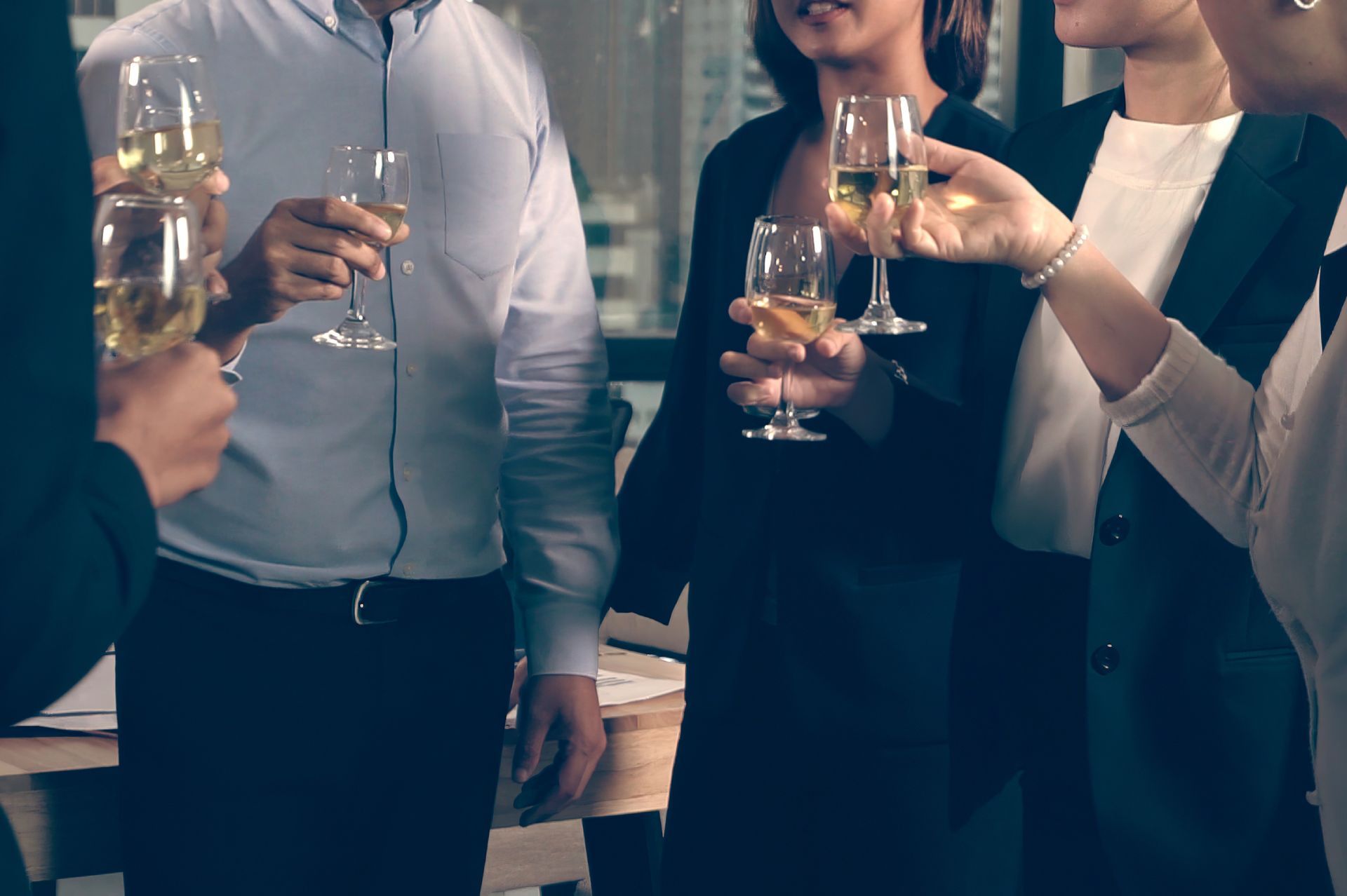People socializing holding wine glasses at a social event.