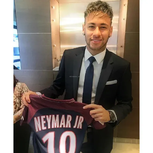 Neymar Jr. sosteniendo una camiseta del PSG.