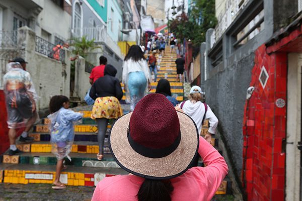 Turista tira foto enquanto outros visitantes sobem as escadas da Escadaria Selarón, no Rio de Janeiro