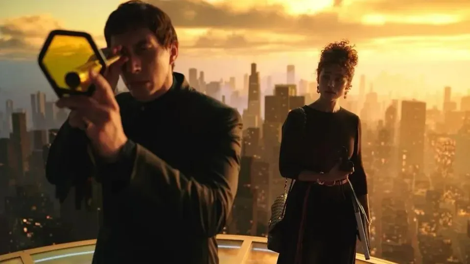A man is looking through a magnifying glass while a woman looks on.