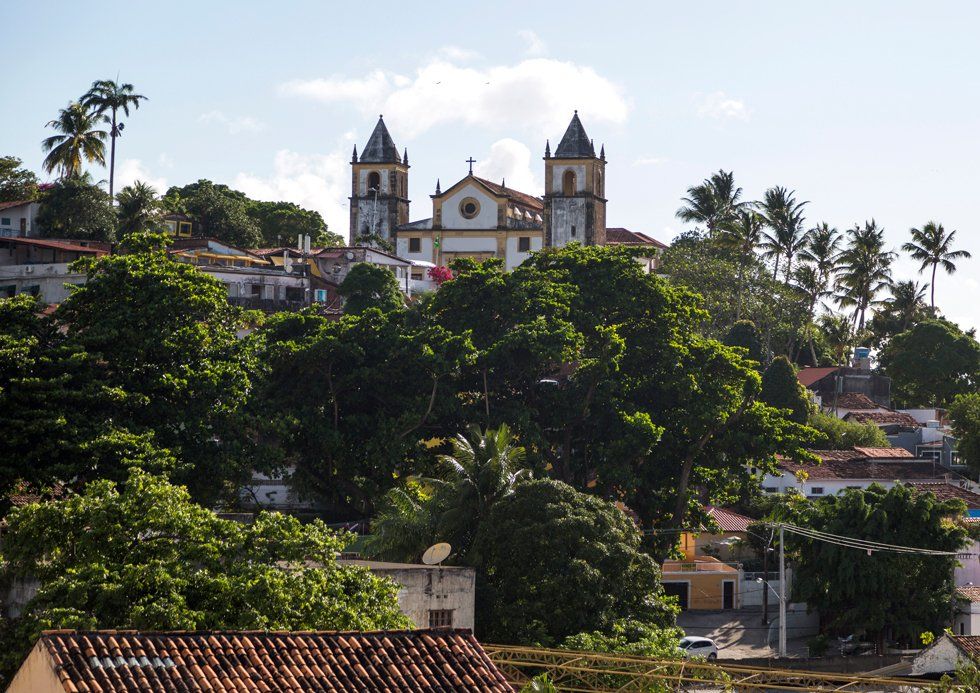 Une église est au sommet d'une colline entourée d'arbres et d'une petite ville
