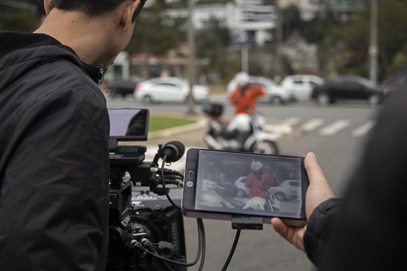 A man is holding a cell phone in front of a camera.