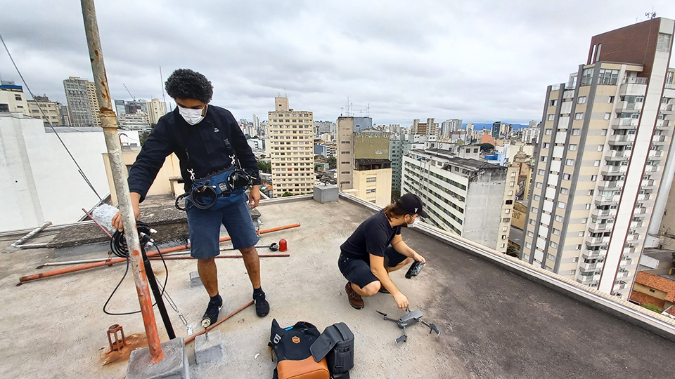 Camera operators prepare a drone shoot on the roof in a building in São Paulo