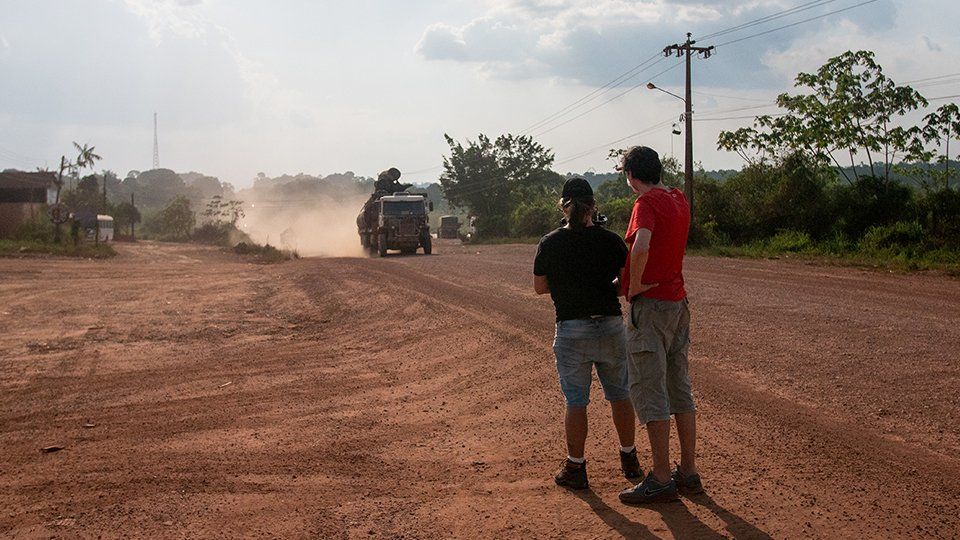 Producer and camera operator look at the road, setting up the shoot