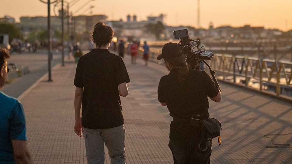 Producer and camera operator walking in a dock in Belen, Brazil