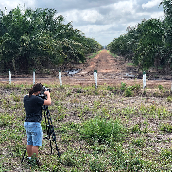 A camera man points his camera to a dirt road