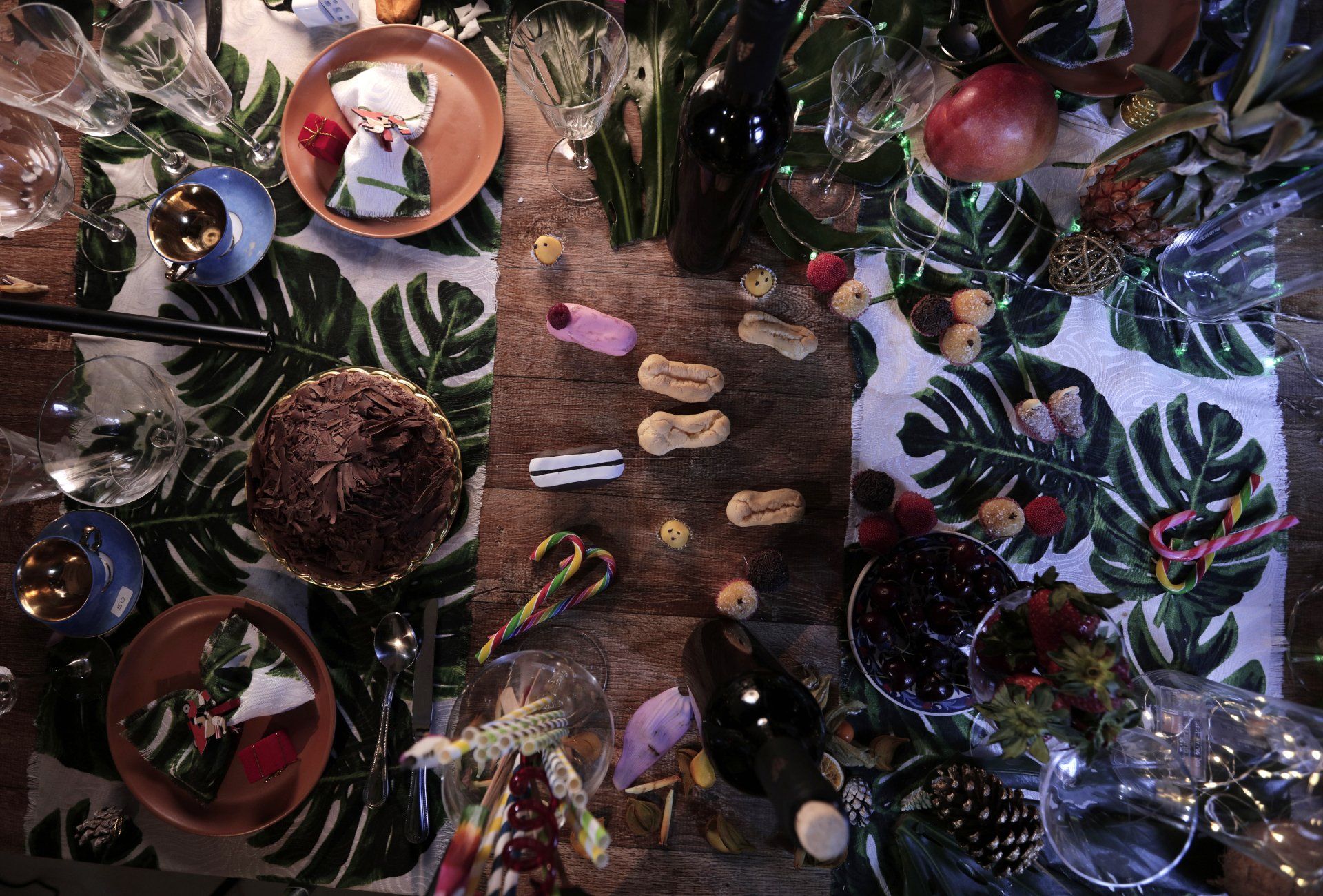 A wooden table with a tropical Christmas setting is set, in the middle six eclair treats